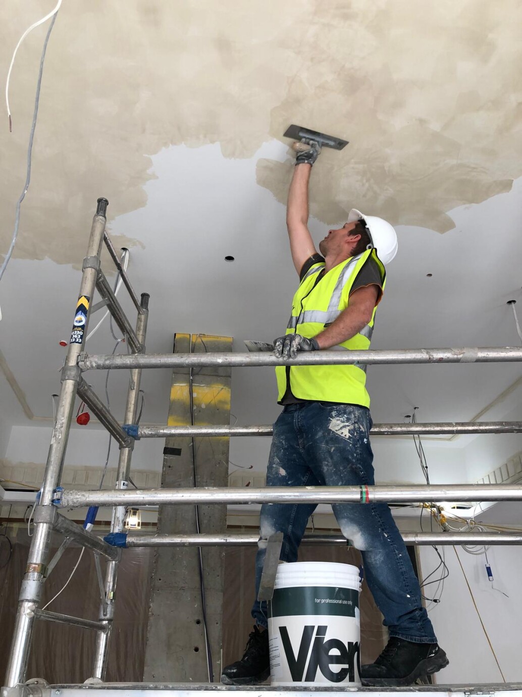 Viero UK craftsman applying Venetian plaster to a ceiling using a steel trowel during installation at The Trafalgar St. James